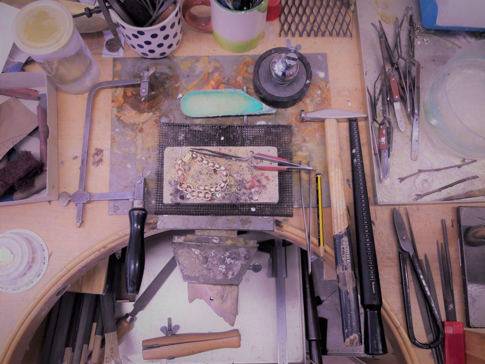 Blick von Oben auf einen Goldschmiede Werktisch mit Werkzeugen für den Trauringkurs