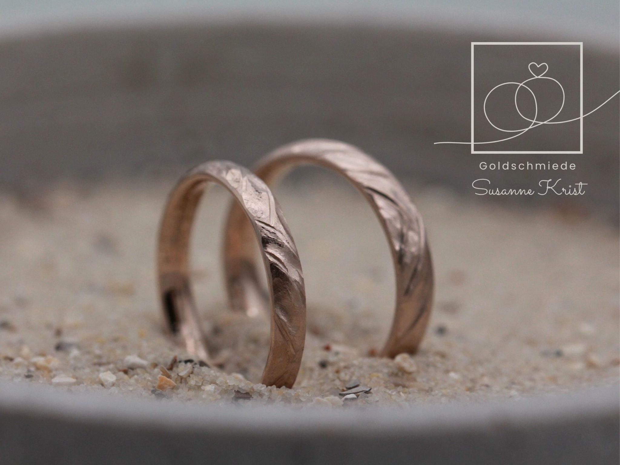Braune Trauringe aus Haselnussgold bzw. Toffeegold mit Buchtmuster.