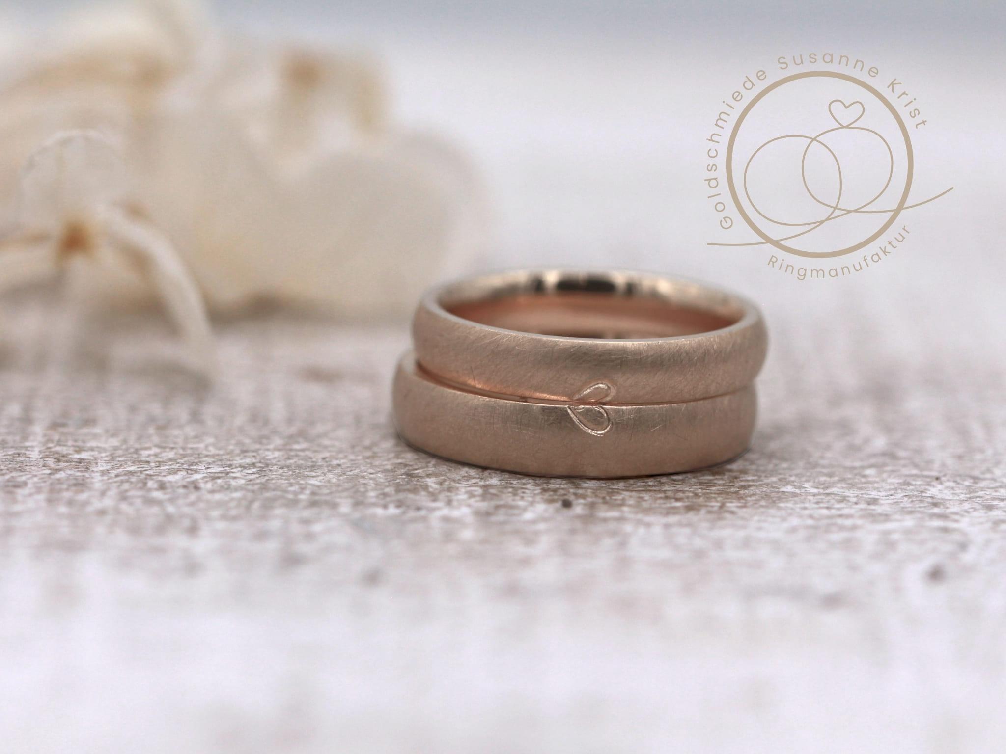 Eheringe aus Haselnussgold bzw. Toffeegold mit Herzhälften.