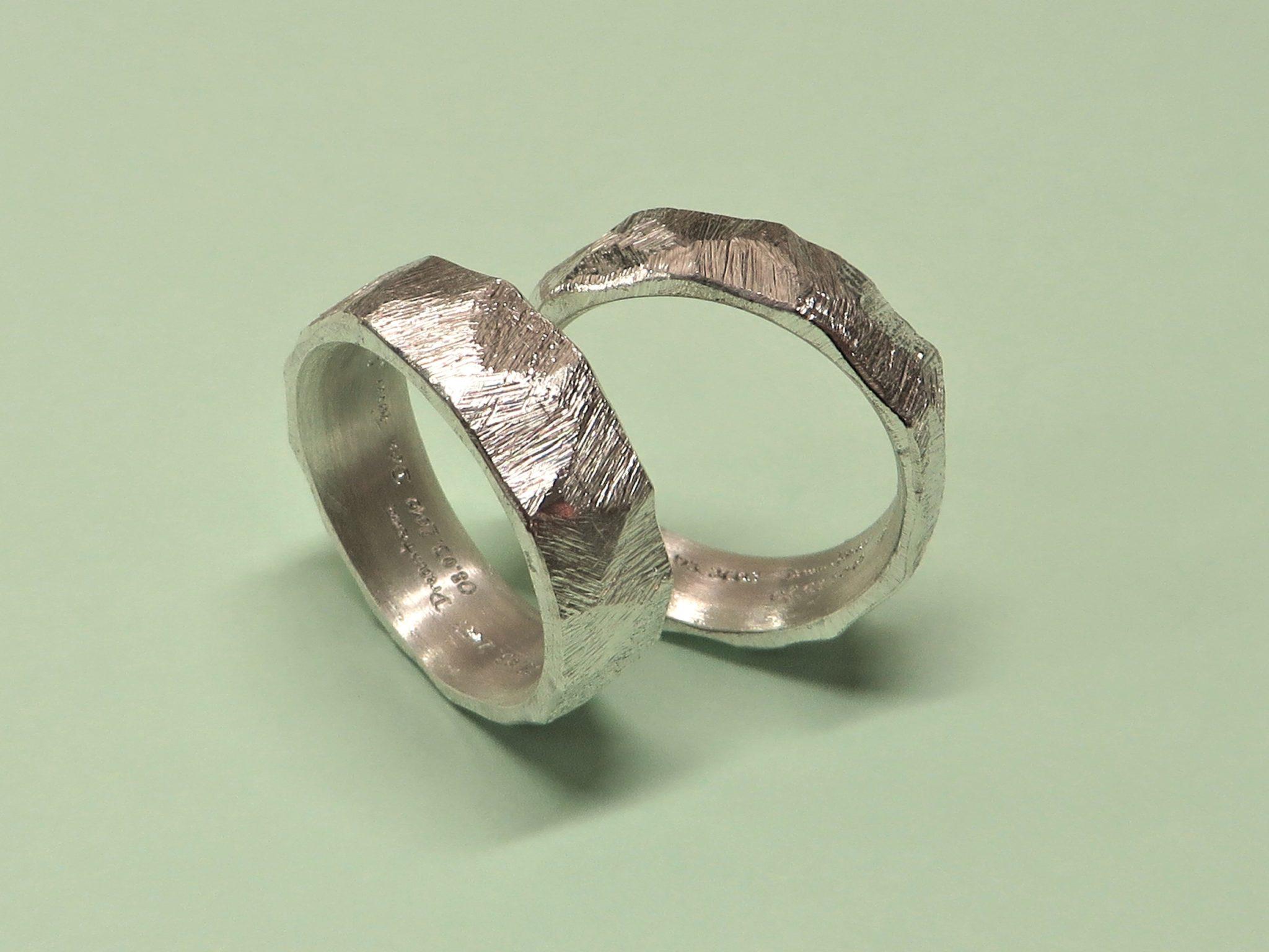 Breite weisse Eheringe mit Facettenhammerschlag namens Fels