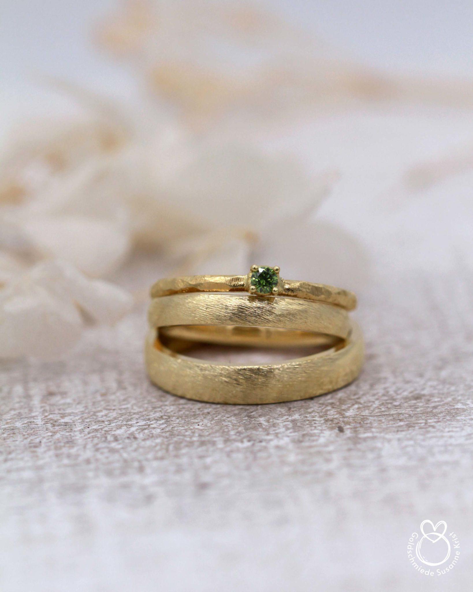 Verlobungsring mit grünem Stein Olivi und Trauringe mit Dünemuster in Gold